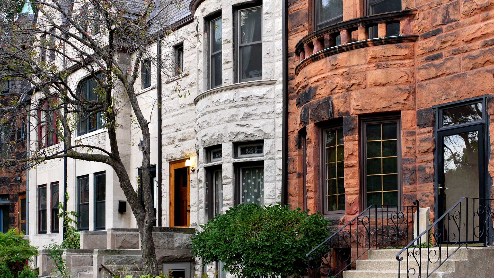 Old Chicago stone walk-up homes along a tree-lined street.